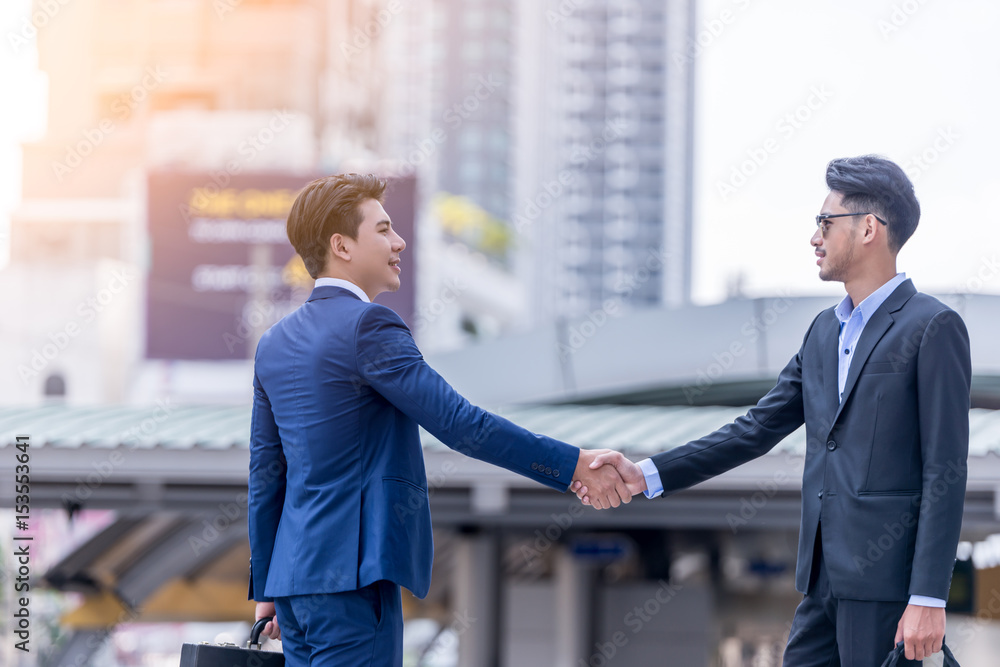 Business handshake concept. shaking hand of two businessman closing a deal city background