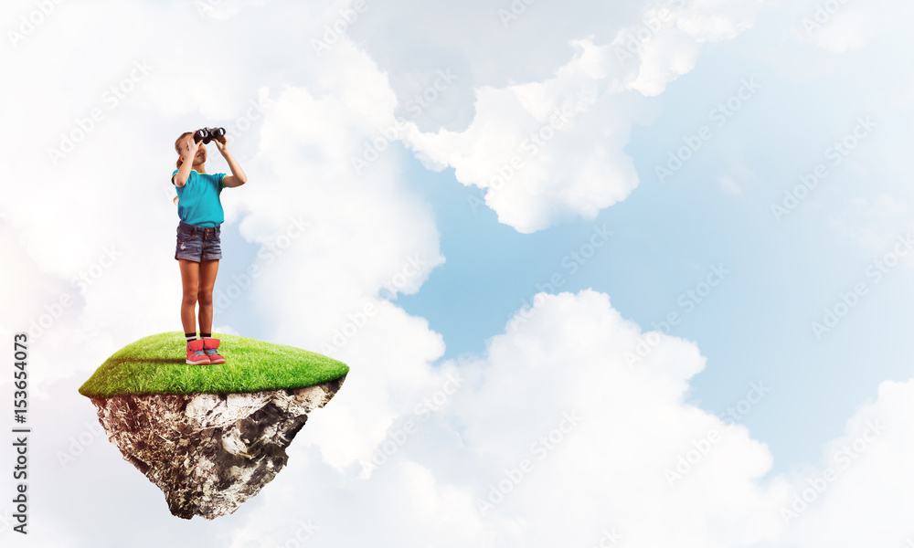 Concept of careless happy childhood with girl looking in binoculars