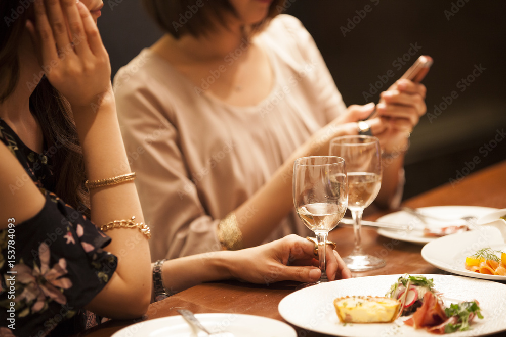 女人在酒吧吃饭时看智能手机