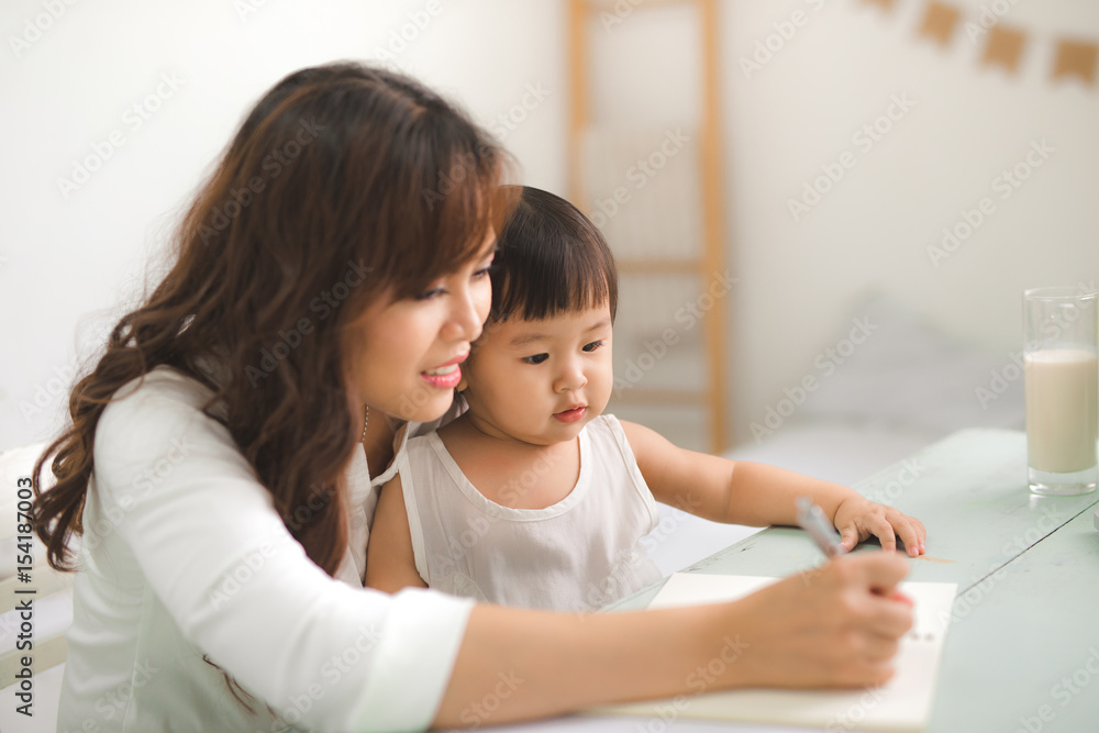 Mother and daughter are learning to write.