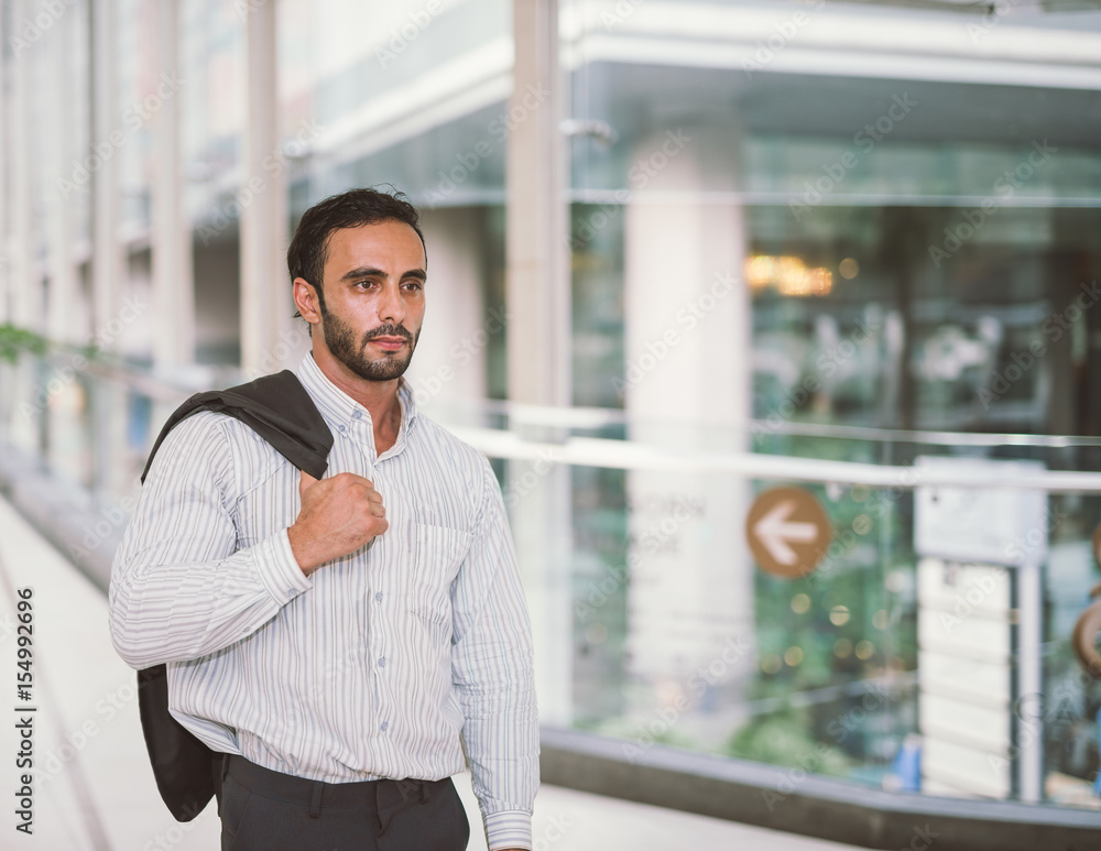 Portrait of handsome Asian businessman standing with formal suit. City background in an urban settin