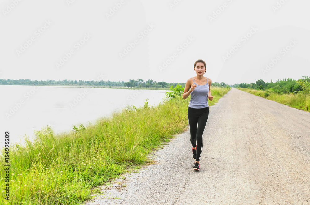 Beautiful woman running on the road at park