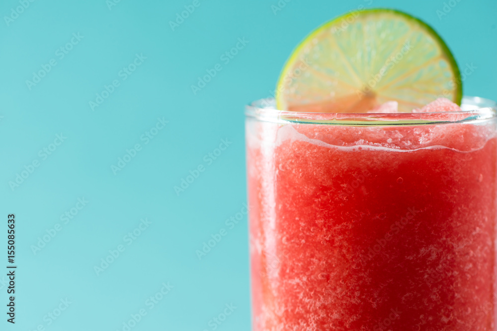 Glass of healthy watermelon juice in summertime on blue background.