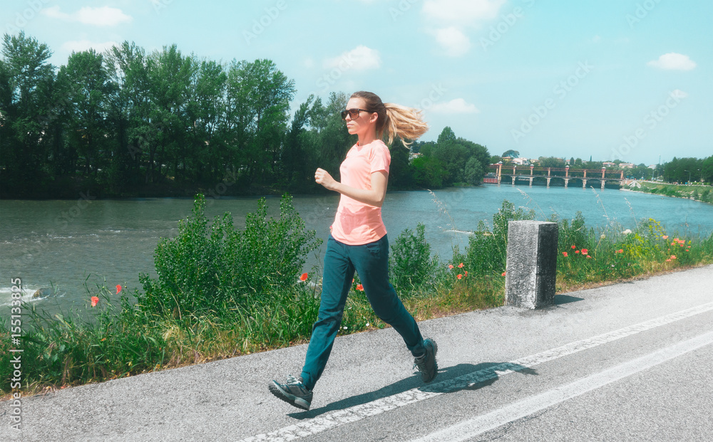 Donna corre e si allena in riva al fiume