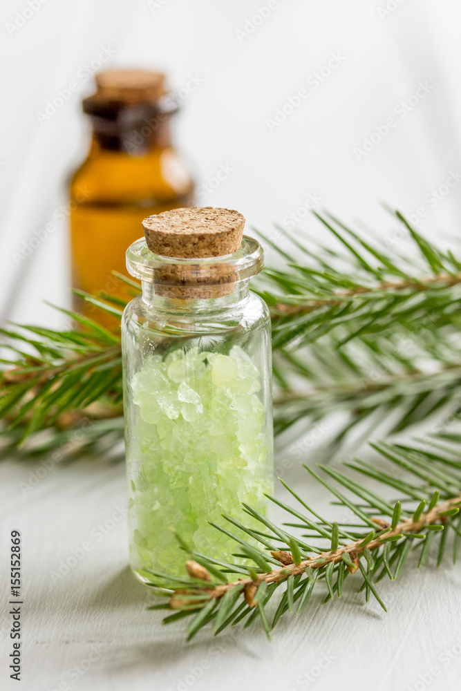 spa with organic spruce oil and sea salt in glass bottles on white table background