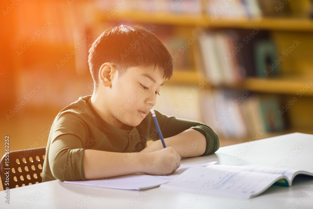 Happy asian child doing homework with smile face.