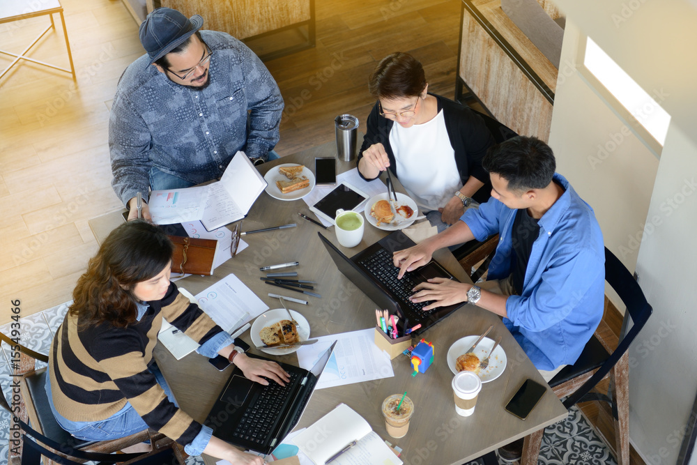 Group of business people having different age in creative business discussing work in coffee shop