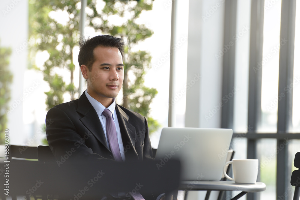 Young Asian businessman  working with laptop computer at outdoor cafe