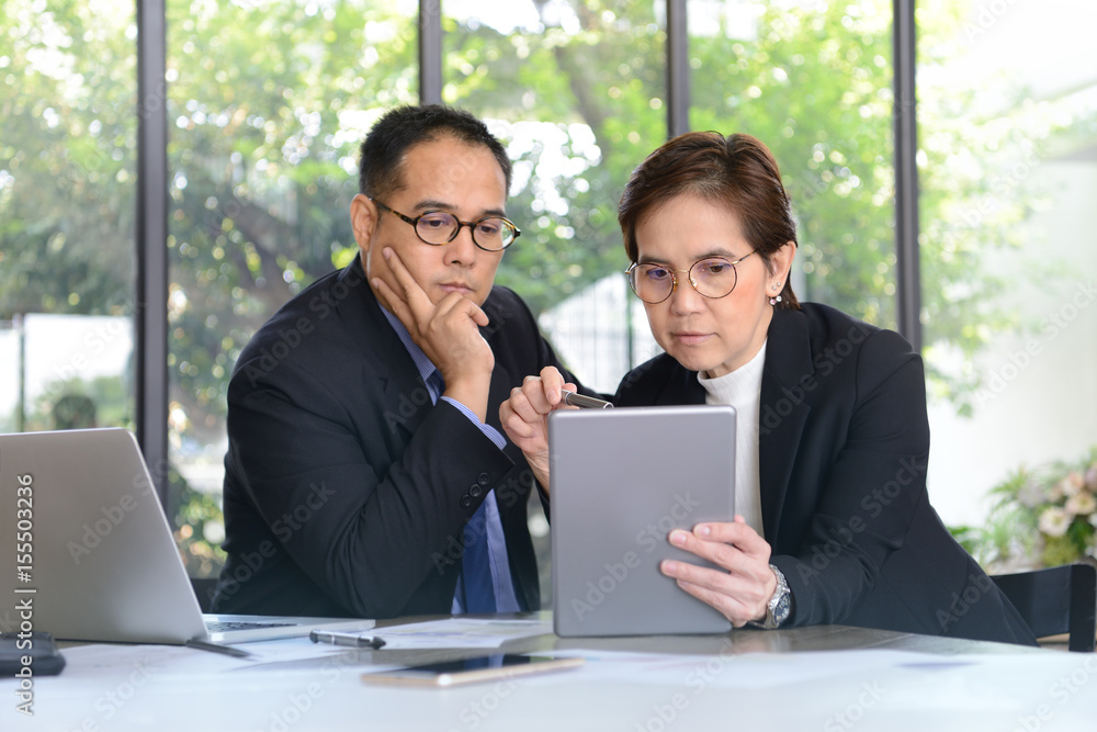 Businessman and businesswoman discussing and working together during a meeting in office