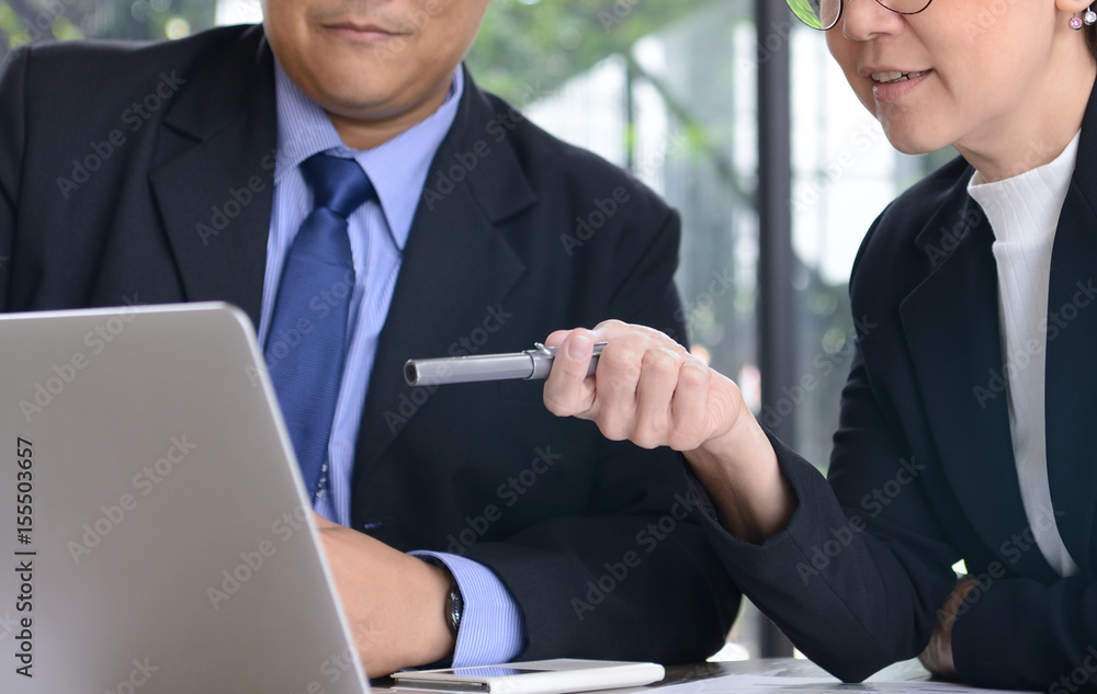 Businessman and businesswoman discussing and working together during a meeting in office