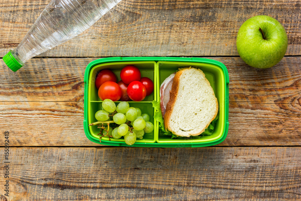 学校木桌背景顶视图午餐盒中的健康食品