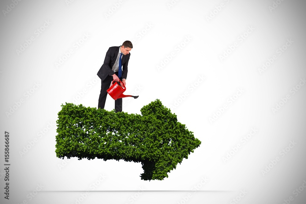 Composite image of businessman holding red watering can