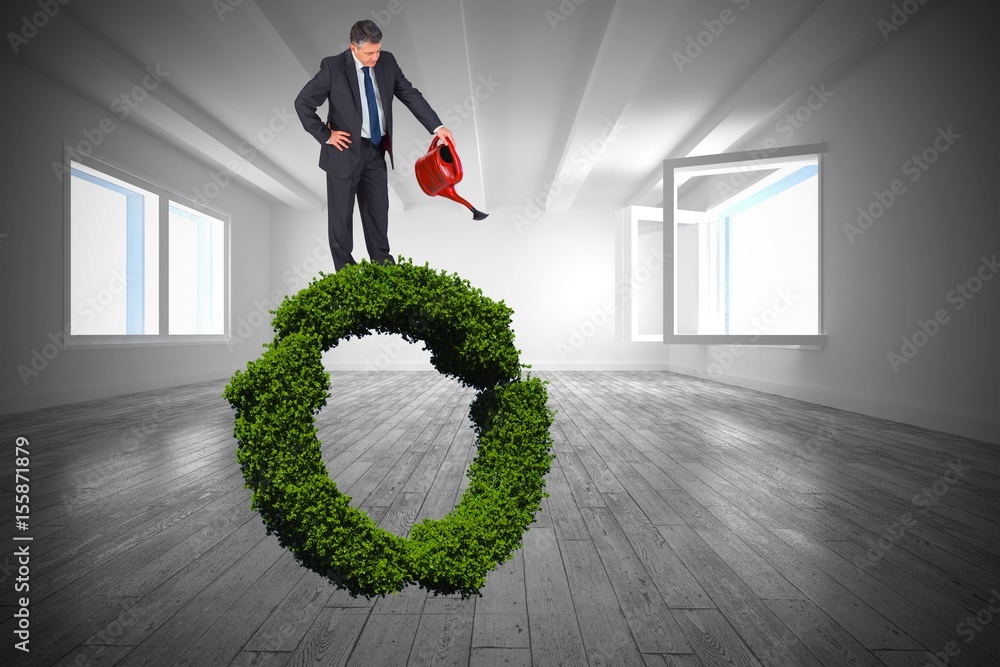 Composite image of mature businessman using watering can