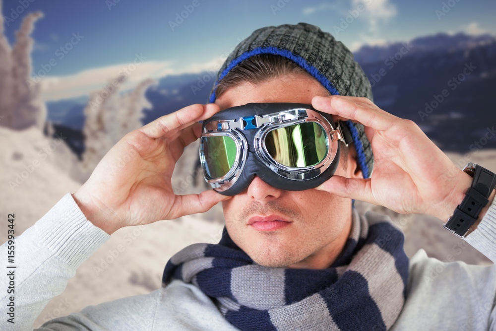 Composite image of unsmiling man wearing aviator goggles