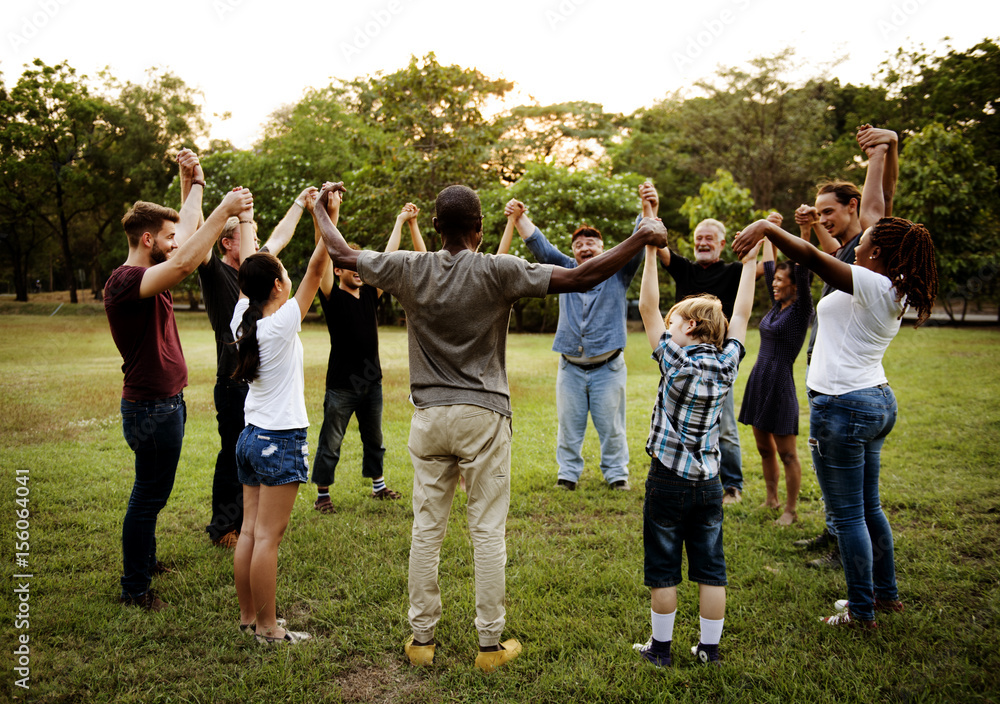 Group of people holding hand together in the park