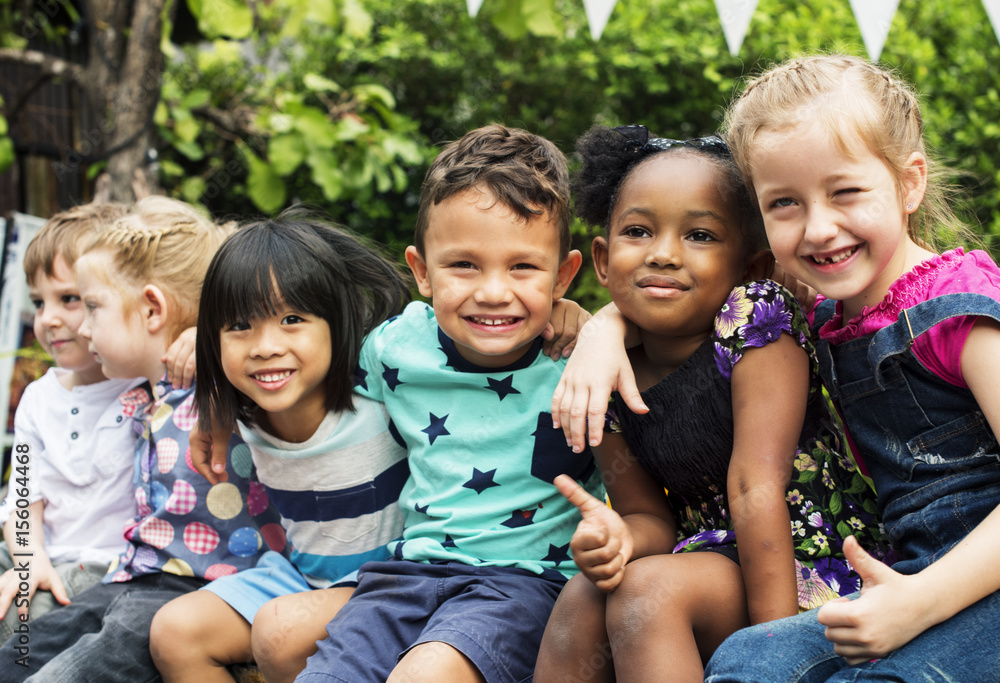 Group of kindergarten kids friends arm around sitting and smiling fun