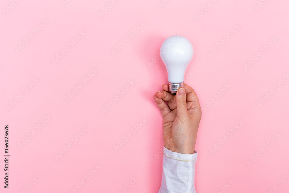 Colored light bulb being held up