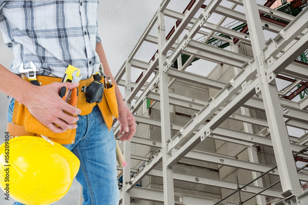 建筑师在建筑背景下系着工具带