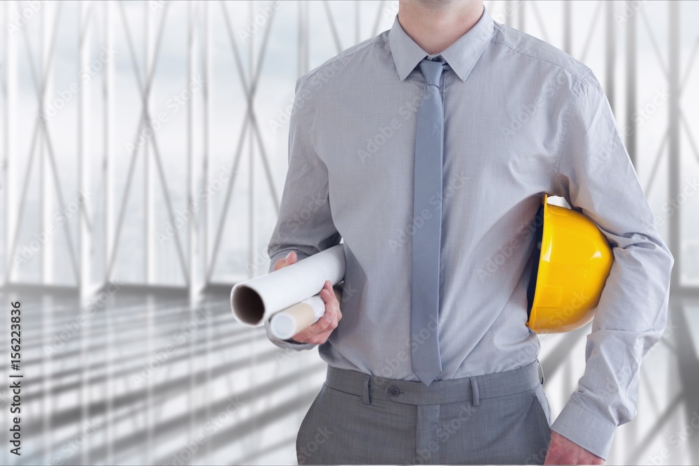 An architect is holding plan and a safety helmet 