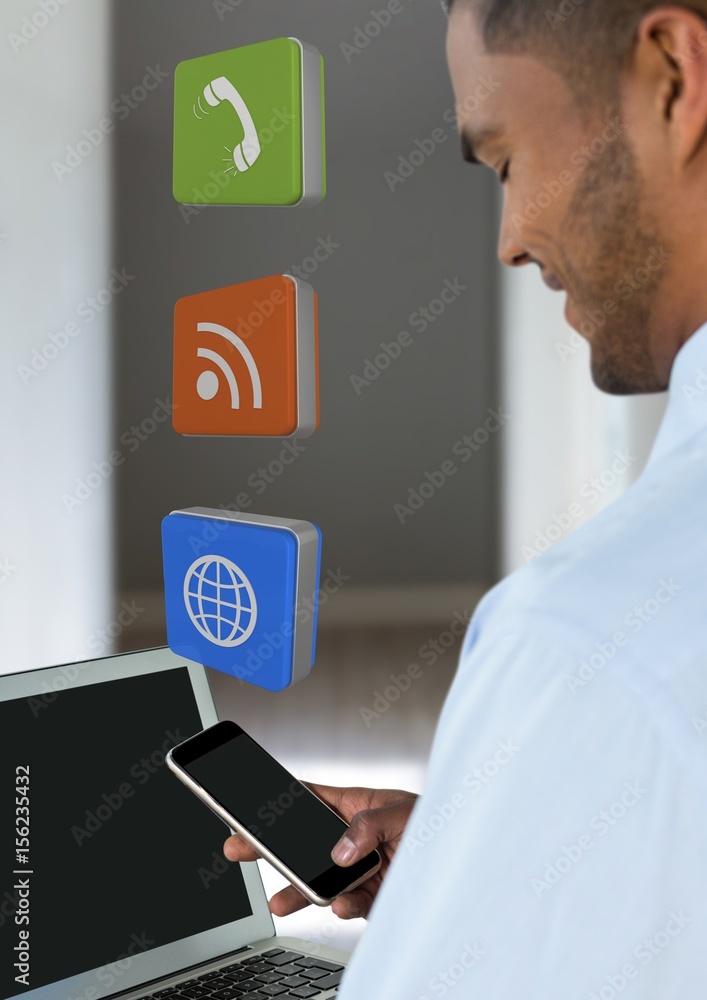 Businessman holding phone with apps icons in room