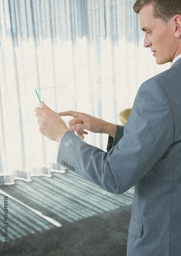 Businessman touching phone in office by window light