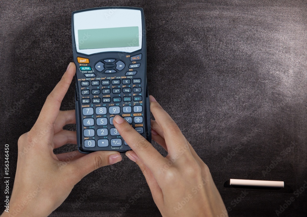 Hands with calculator against chalkboard