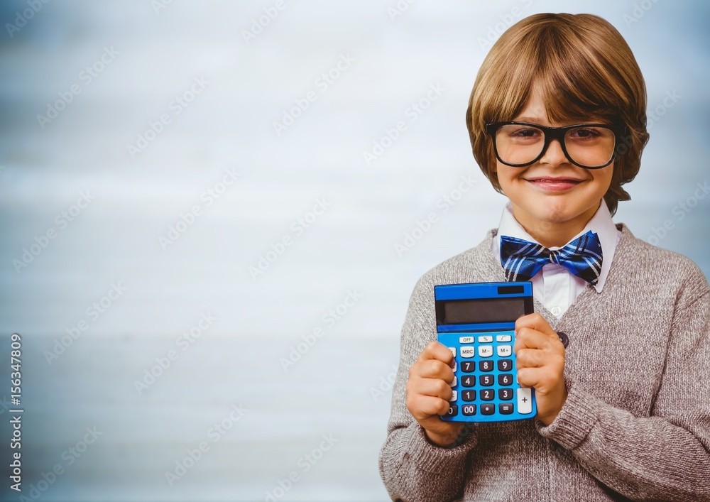 Boy smiling with calculator against blurry blue wood panel