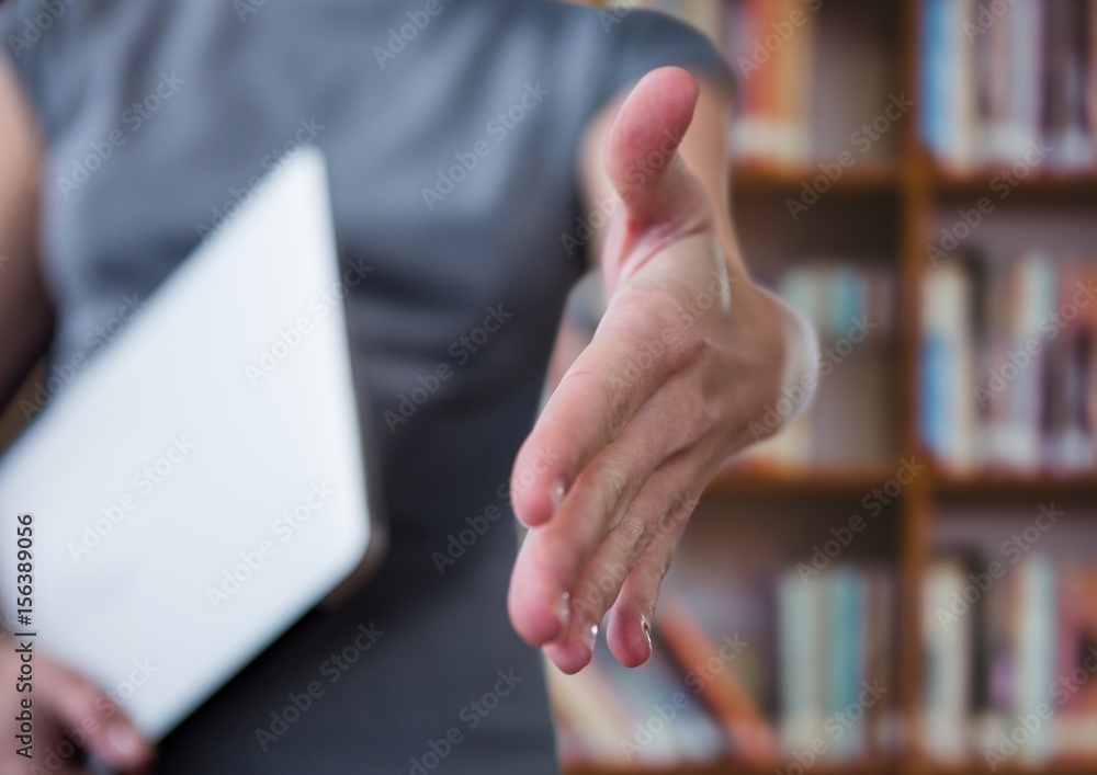 businesswoman giving hand with laptop in the other hand. Library