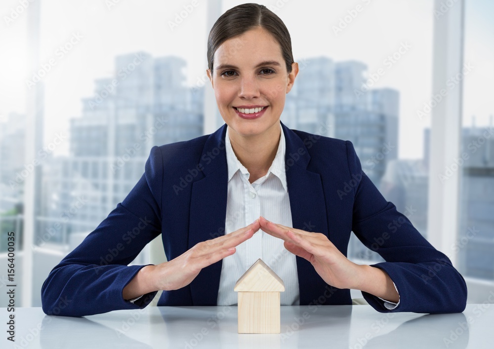 House under womans hands by window and city