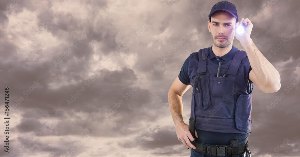 Portrait of security guard holding flashlight against cloudy sky