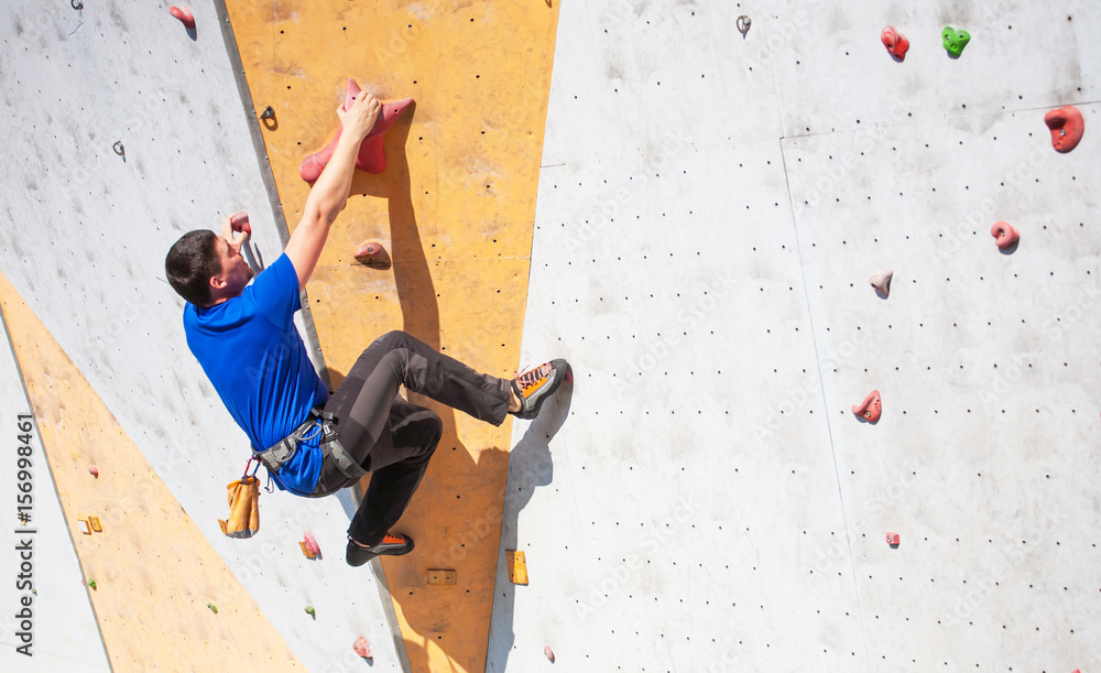 The man climbs on the climbing wall.