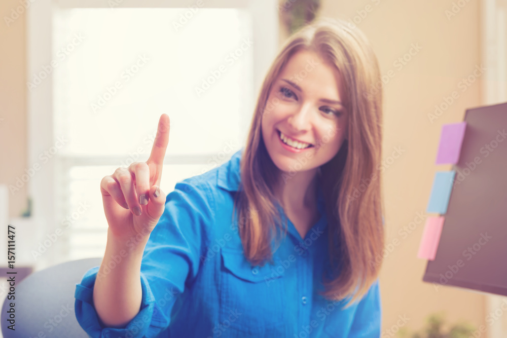 Young woman using pointing to something in her home office