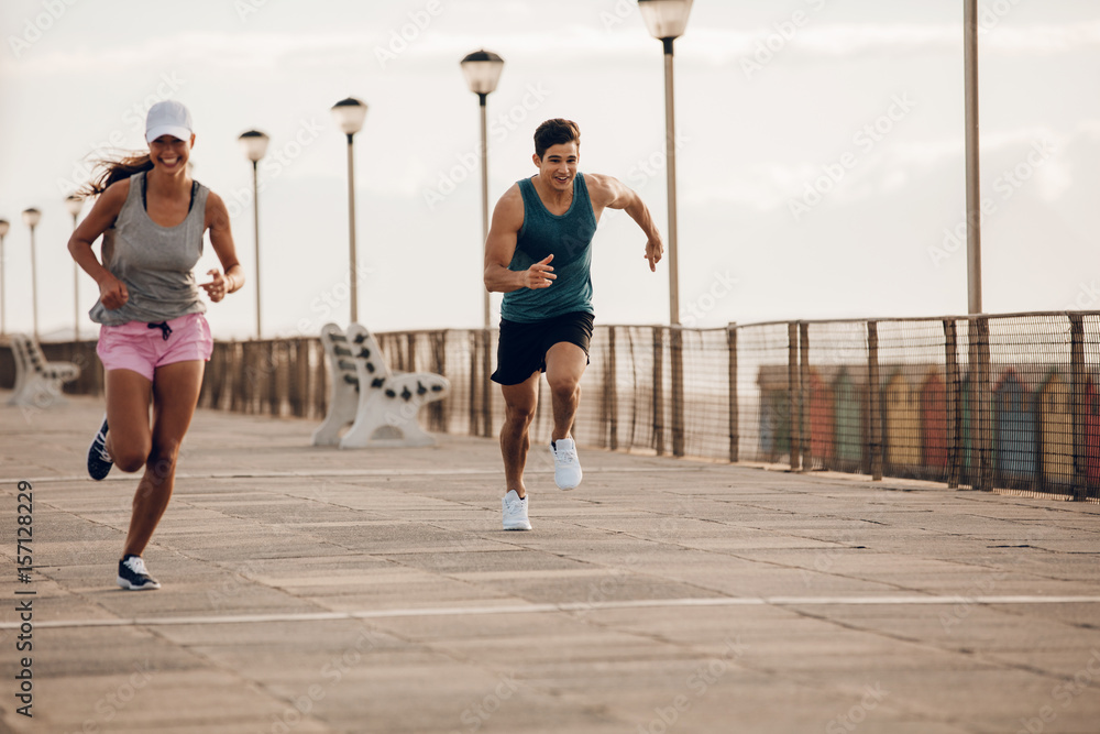 Young people sprinting along a seaside promenade