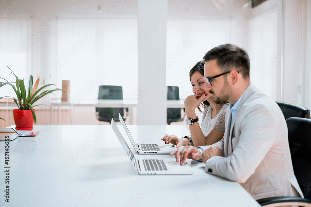 Couple of young designers working at modern office