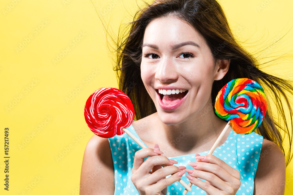 Young woman holding lollipops