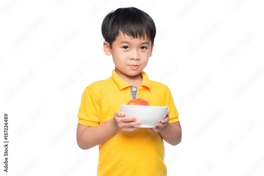 Happy Asian boy holding red apple in bowl.