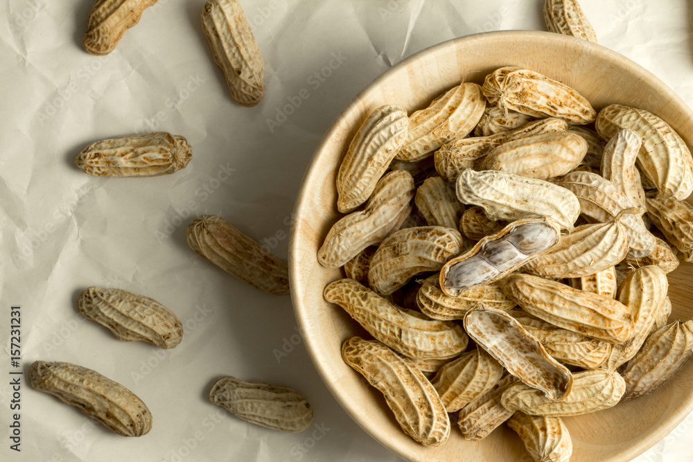 boiled peanuts in wooden cup on crumpled paper