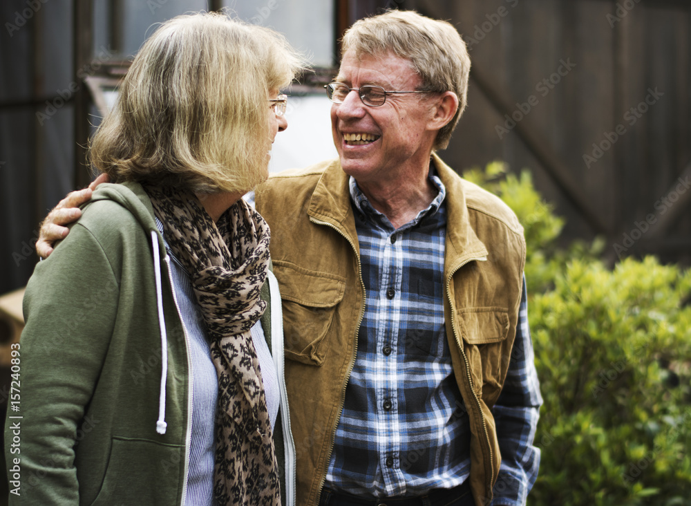 Senior couple planting vegetables at garden backyard