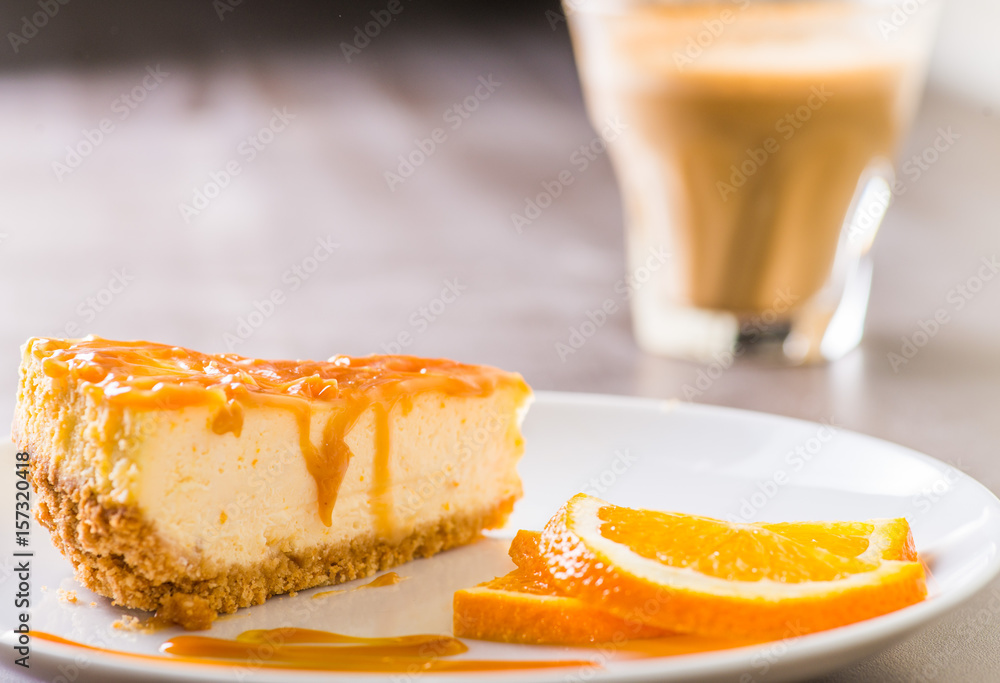 piece of cheesecake served on a white plate with a cup of coffee