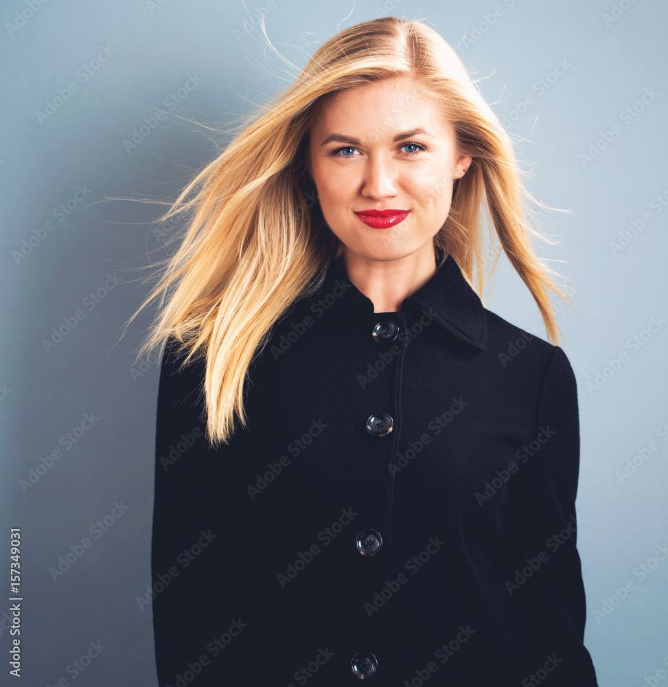 Beautiful blonde woman in a black coat