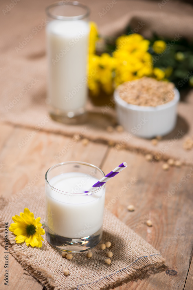 Soy milk or soya milk and soy beans in spoon on wooden table.