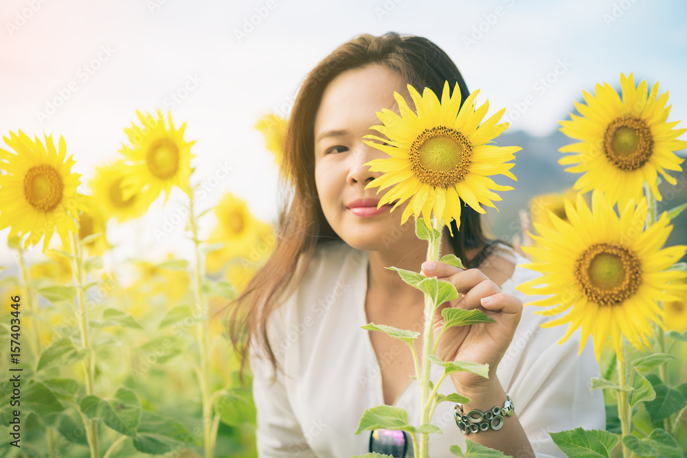 向日葵和一个躲在它后面的女人