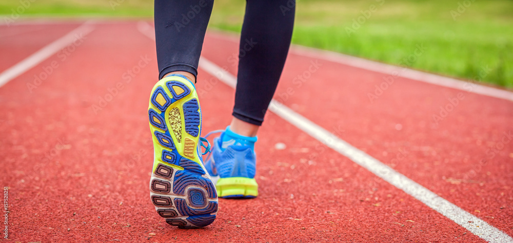 Athletic woman feet on running track close up on shoe