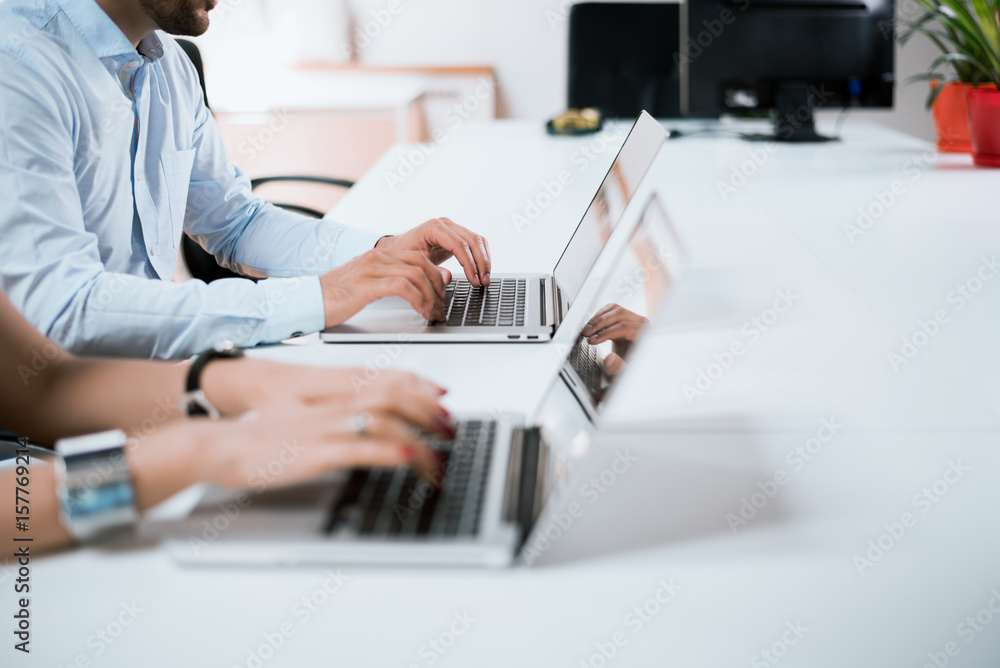 Young group of people doing their jobs on laptops.