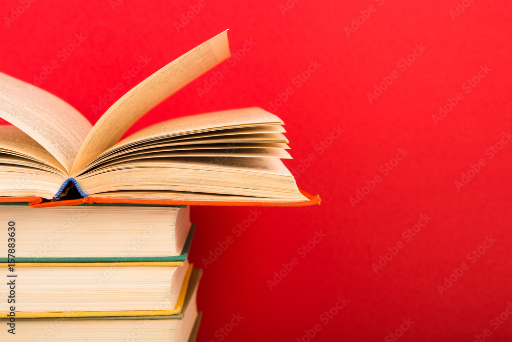 education and wisdom concept - open book on wooden table, color background