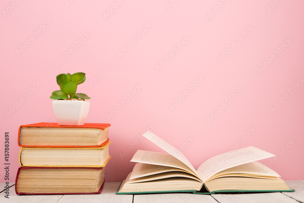 education and wisdom concept - open book on wooden table, color background