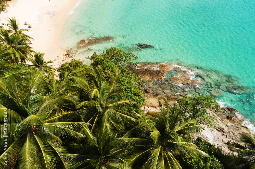 Aerial veiw of the palm trees on the beautiful cliff and paradise beach with clear turquoise sea. Su