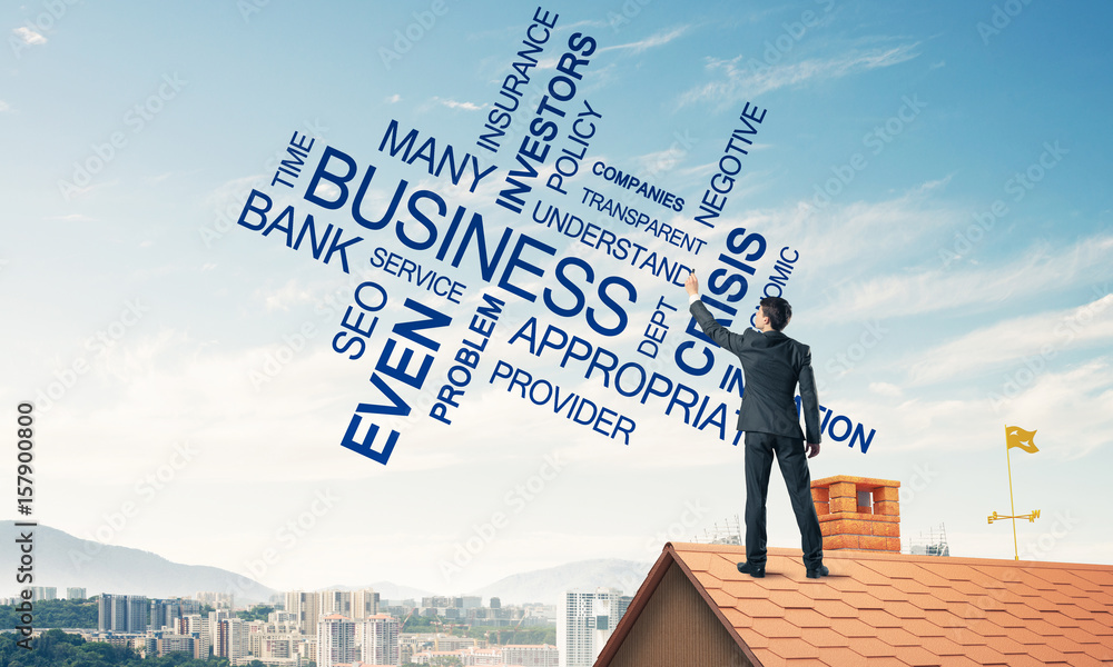 Young businessman standing on house roof and writing leadership 