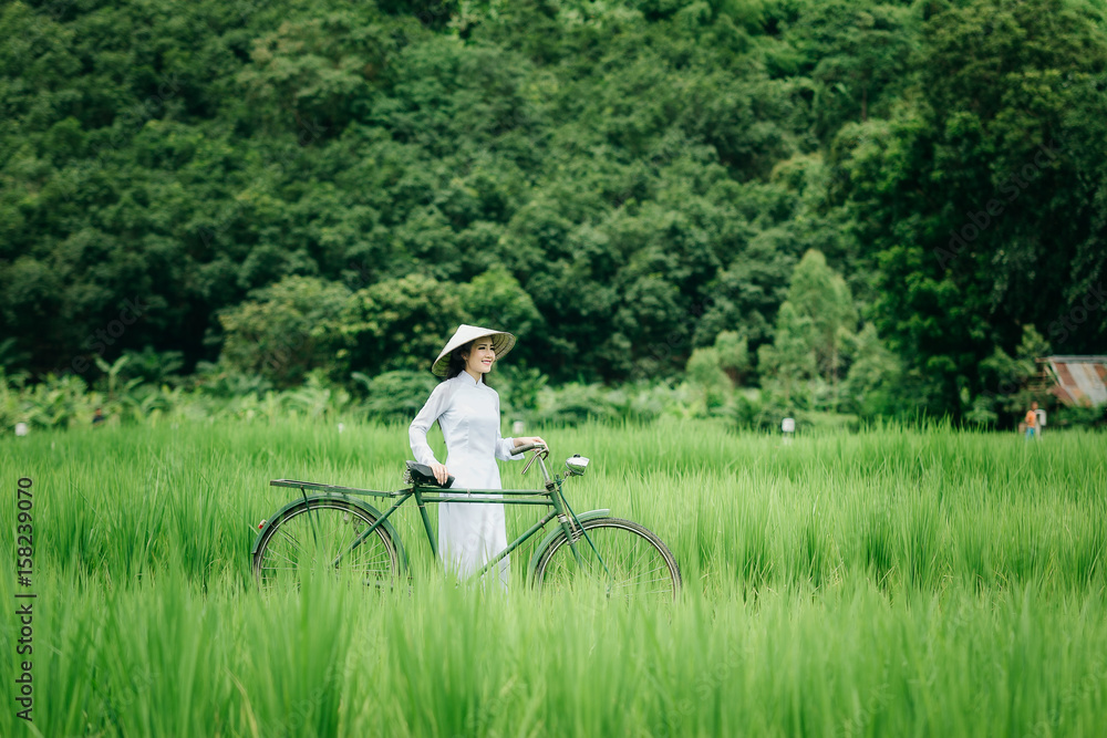 Beautiful woman in white Ao dai Vietnam Traditional dress at farmland