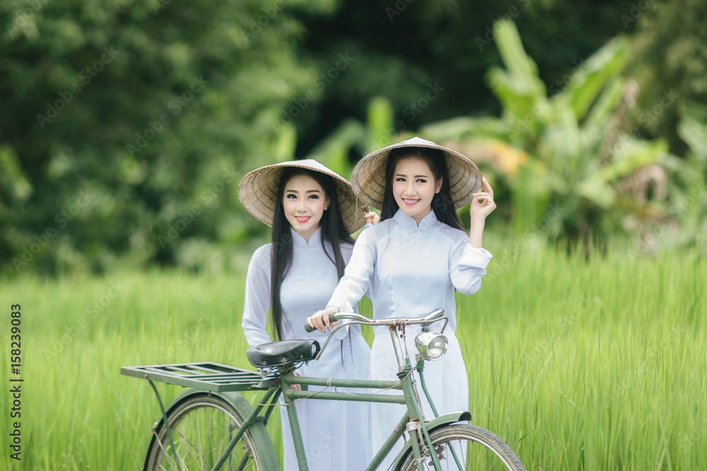 身穿白色Ao-dai越南传统服饰的美女在农田里